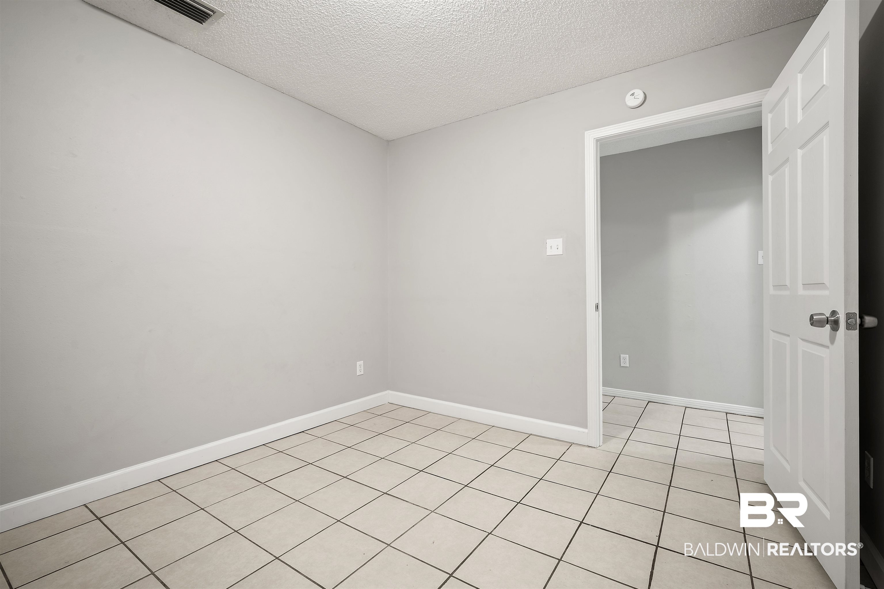 963 Shady Brook Drive Mobile, AL 36606 - Photo 17 of 20 Unfurnished room with a textured ceiling, light tile patterned flooring, baseboards, and a smoke detector