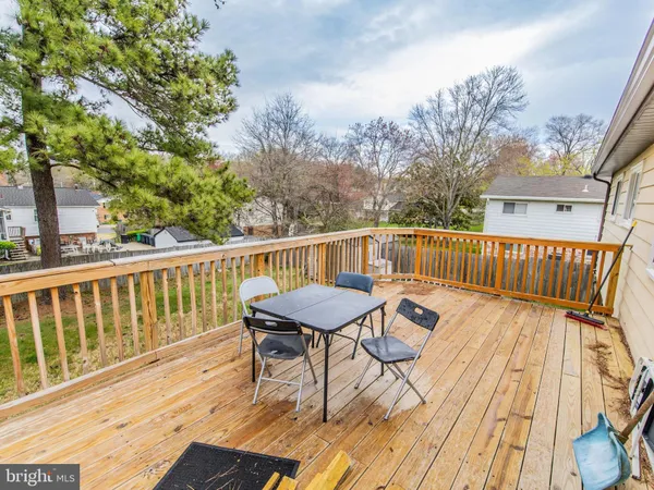 a view of a house with wooden deck and furniture