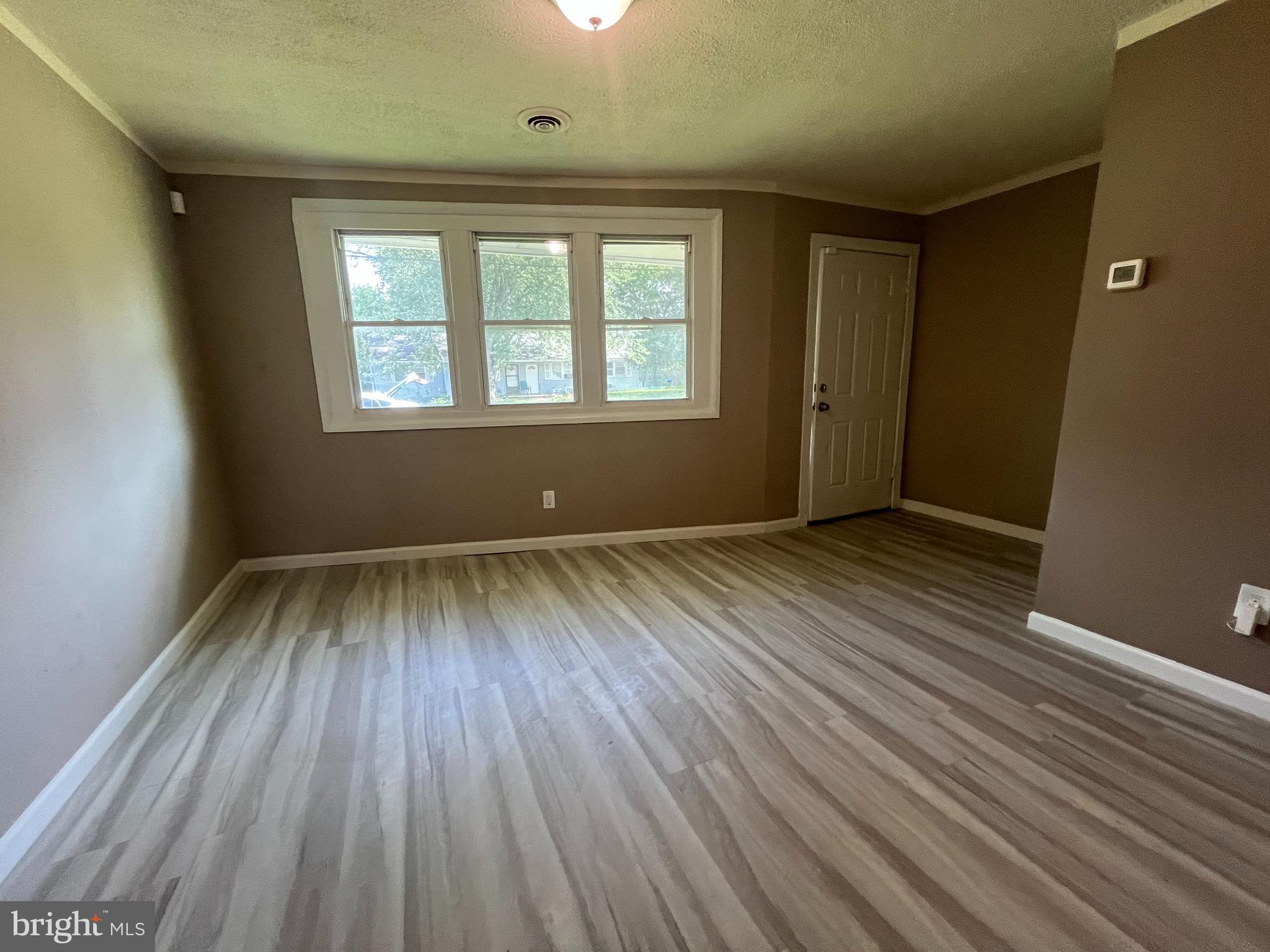 112 Kinsley Road Pemberton, NJ 08068 - Photo 3 of 13 an empty room with wooden floor and windows