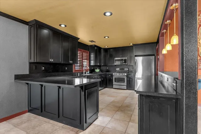 a kitchen with granite countertop stainless steel appliances wooden cabinets and a sink