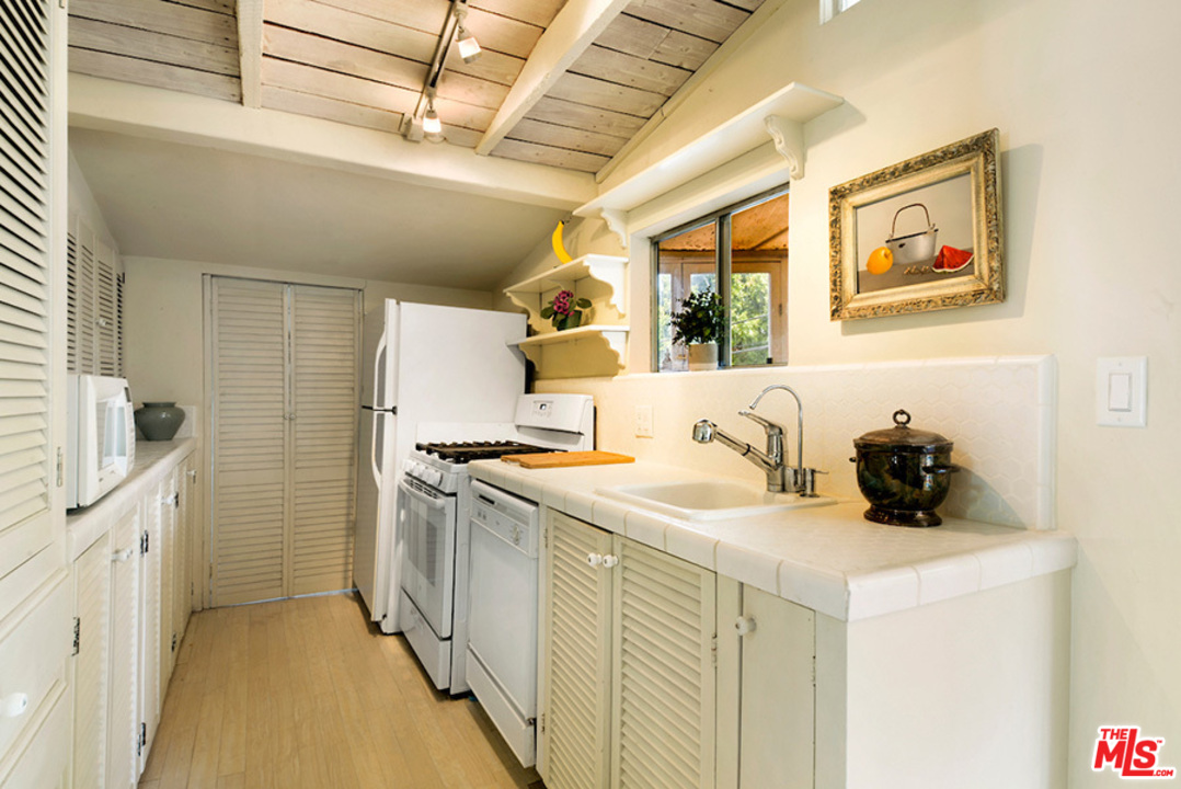 8954 1/2 Norma Place West Hollywood, CA 90069 - Photo 6 of 14 a kitchen with stainless steel appliances granite countertop a sink and a stove next to a window