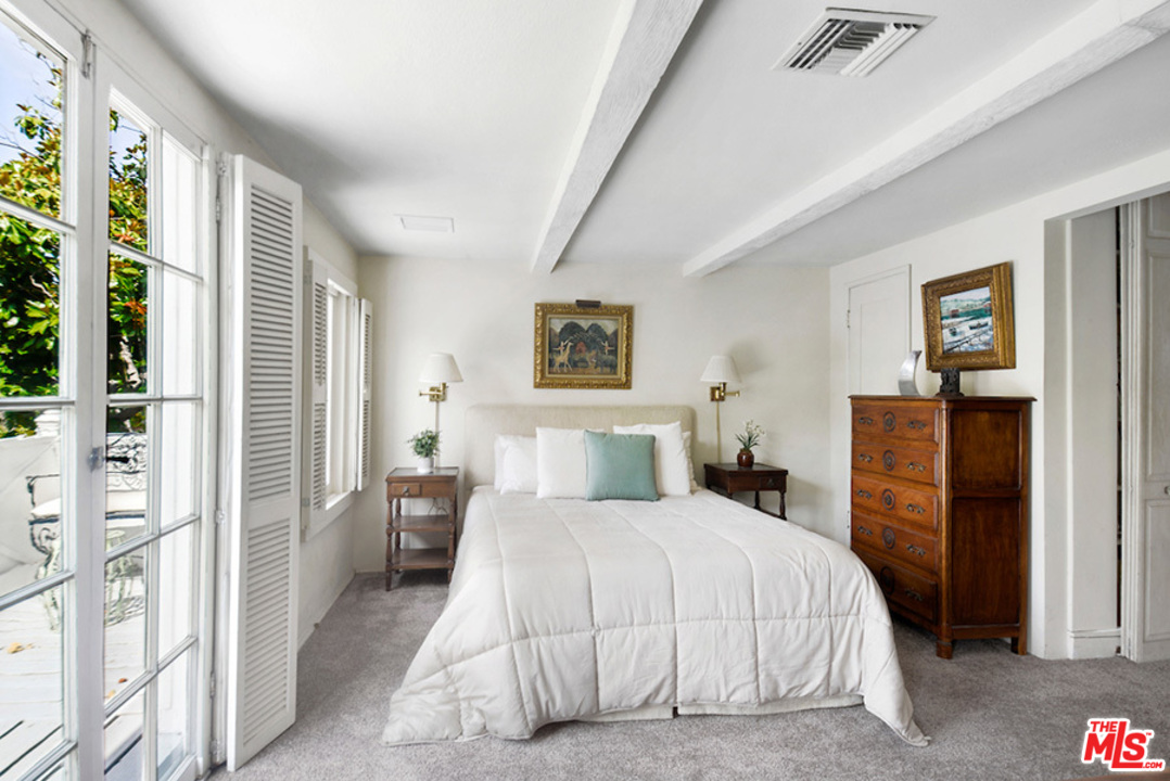 8954 1/2 Norma Place West Hollywood, CA 90069 - Photo 7 of 14 a bedroom with a bed and a large mirror