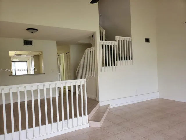a view of staircase with railing and a window