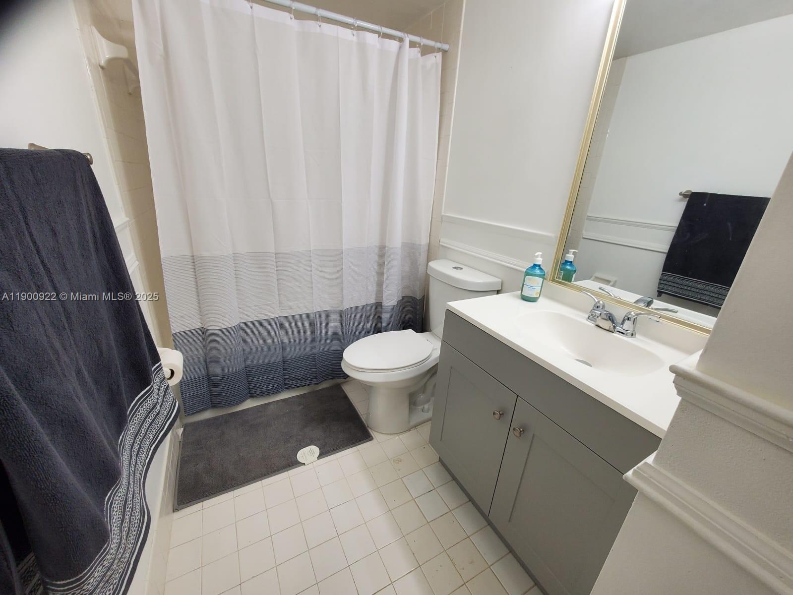4206 Southwest 87th Terrace, Unit 4206 Davie, FL 33328 - Photo 24 of 37 a bathroom with a sink a toilet and shower curtain