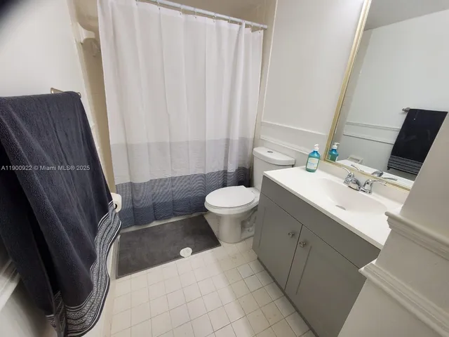 a bathroom with a sink a toilet and shower curtain