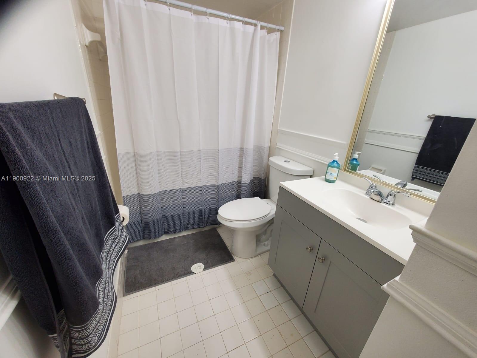4206 Southwest 87th Terrace, Unit 4206 Davie, FL 33328 - Photo 25 of 37 a bathroom with a sink a toilet and shower curtain
