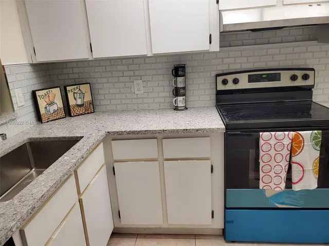 a kitchen with granite countertop a stove and a sink