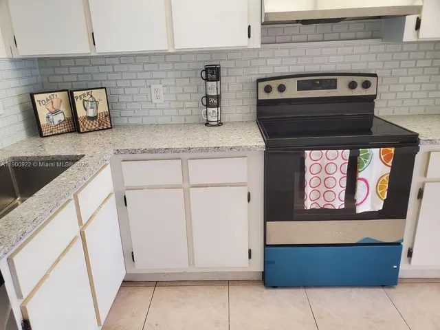 a kitchen with granite countertop a stove and a microwave
