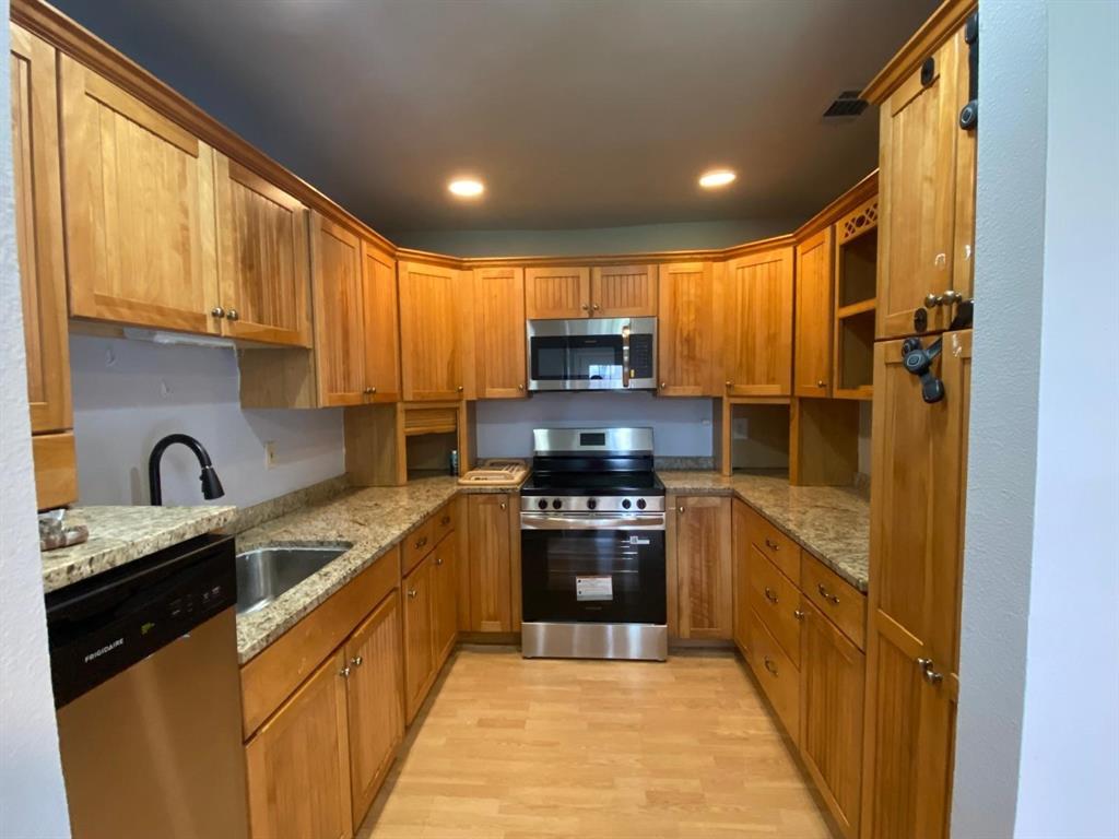 5217 Kisor Drive The Colony, TX 75056 - Photo 4 of 15 a kitchen with stainless steel appliances granite countertop a refrigerator a sink dishwasher a stove and a microwave oven with cabinets