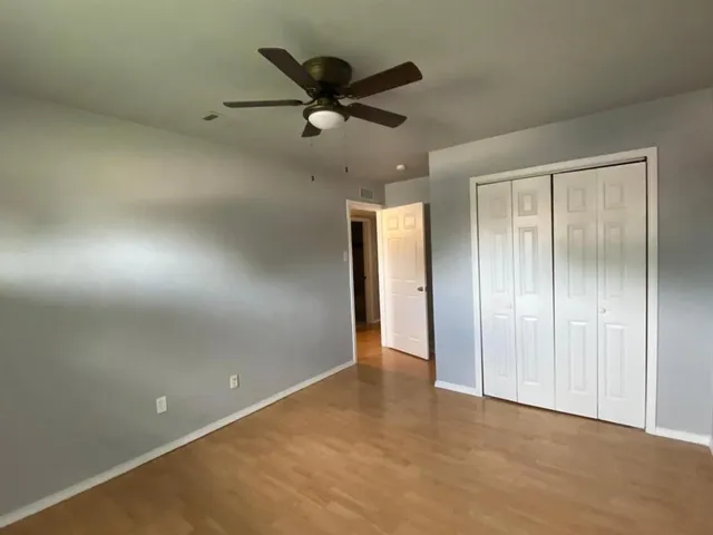 an empty room with closet and fan