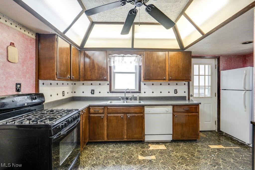516 Floyd Street Akron, OH 44310 - Photo 12 of 50 Kitchen featuring white appliances, a ceiling fan, decorative backsplash, and brown cabinets