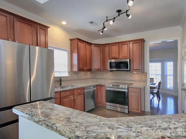 a kitchen with stainless steel appliances granite countertop a refrigerator stove microwave and sink