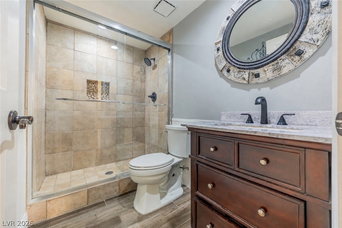 2504 Putting Green Drive Henderson, NV 89074 - Photo 19 of 56 This bathroom features a sleek glass-enclosed shower, a modern vanity with ample storage, and stylish flooring.
