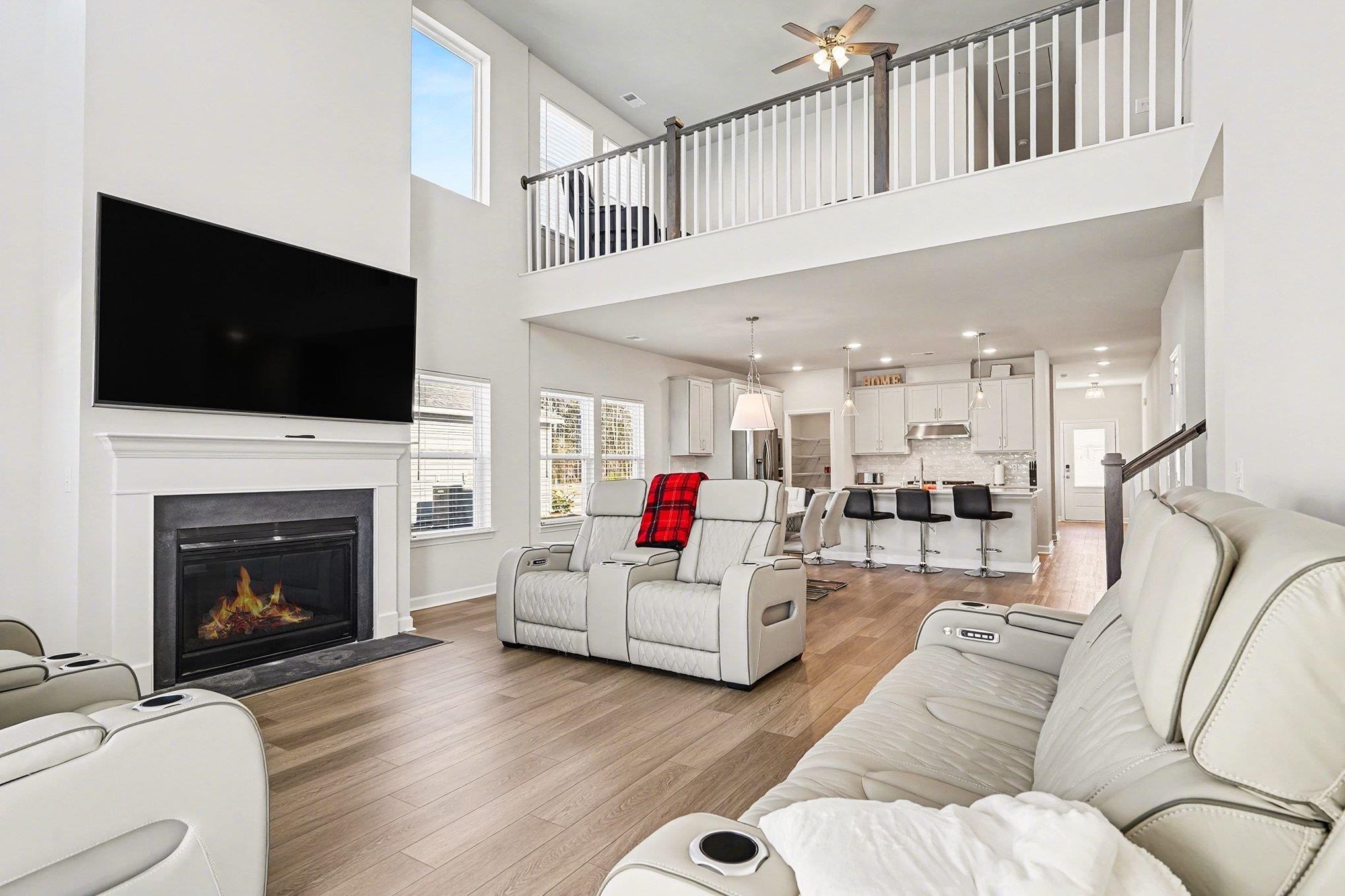 3005 Palma Way Myrtle Beach, SC 29579 - Photo 3 of 30 Living room featuring light wood finished floors, a fireplace with flush hearth, a ceiling fan, recessed lighting, and a towering ceiling