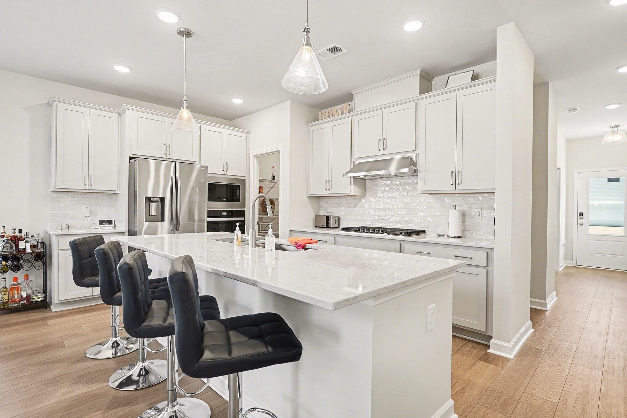 3005 Palma Way Myrtle Beach, SC 29579 - Photo 5 of 30 Kitchen featuring white cabinetry, a kitchen breakfast bar, decorative backsplash, appliances with stainless steel finishes, and recessed lighting