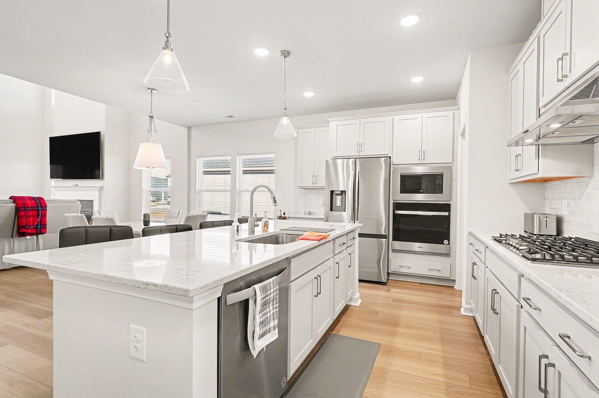 3005 Palma Way Myrtle Beach, SC 29579 - Photo 6 of 30 Kitchen with stainless steel appliances, light stone countertops, white cabinetry, hanging light fixtures, and recessed lighting