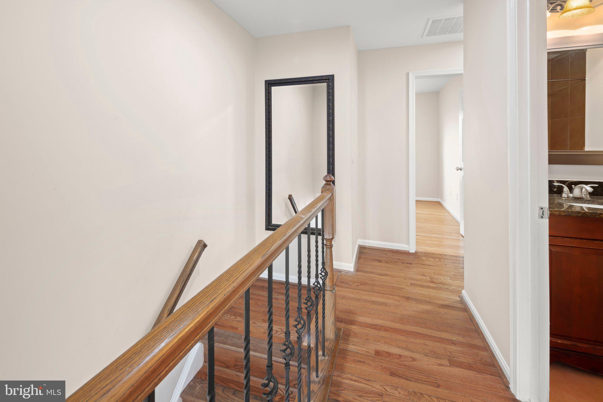 1451 Bluemont Court Herndon, VA 20170 - Photo 14 of 33 a view of a hallway with wooden floor and staircase