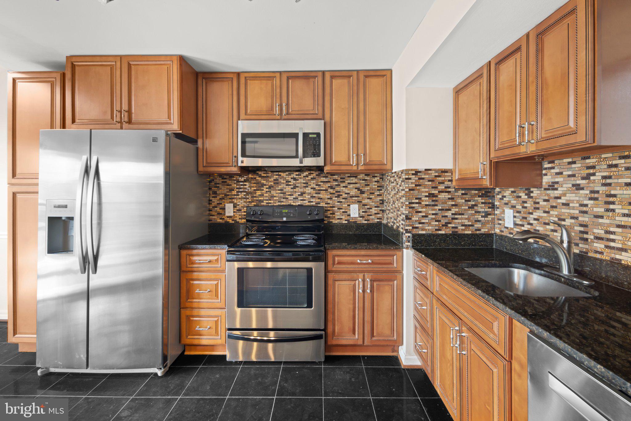 1451 Bluemont Court Herndon, VA 20170 - Photo 8 of 33 a kitchen with stainless steel appliances granite countertop a sink stove and refrigerator