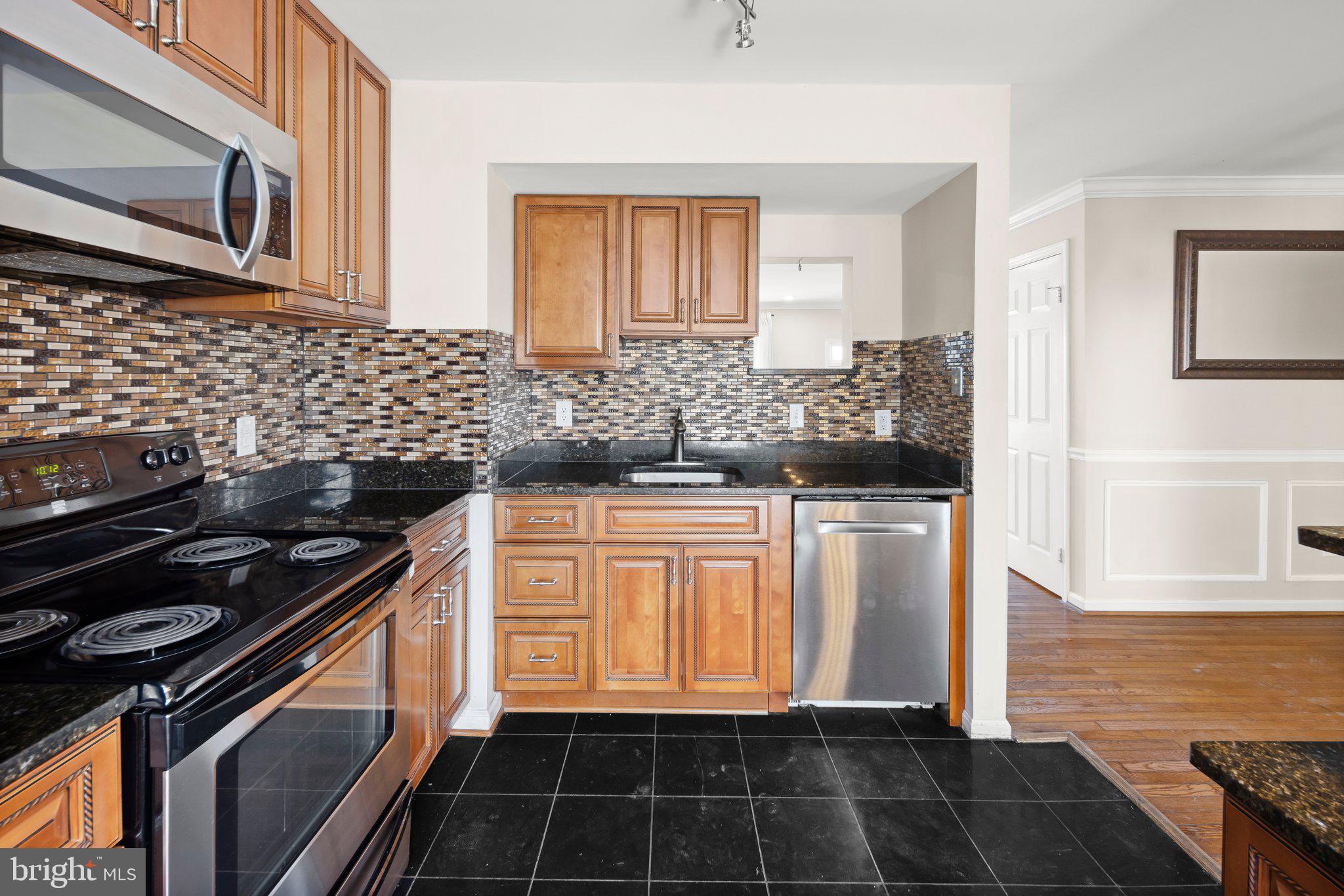 1451 Bluemont Court Herndon, VA 20170 - Photo 9 of 33 a kitchen with granite countertop a stove and a refrigerator