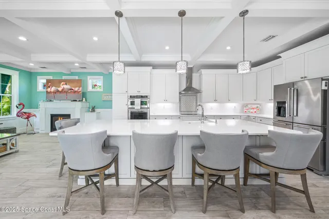 a kitchen with a dining table chairs and refrigerator