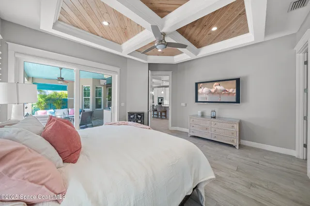 a spacious bedroom with a bed and a flat screen tv