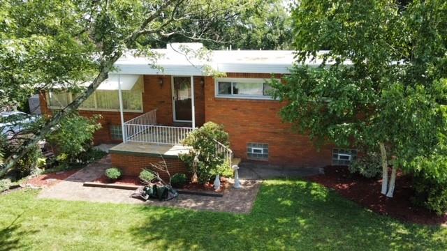a view of a house with backyard garden and sitting area