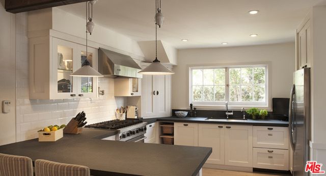 a kitchen with stainless steel appliances granite countertop a sink a stove and a refrigerator