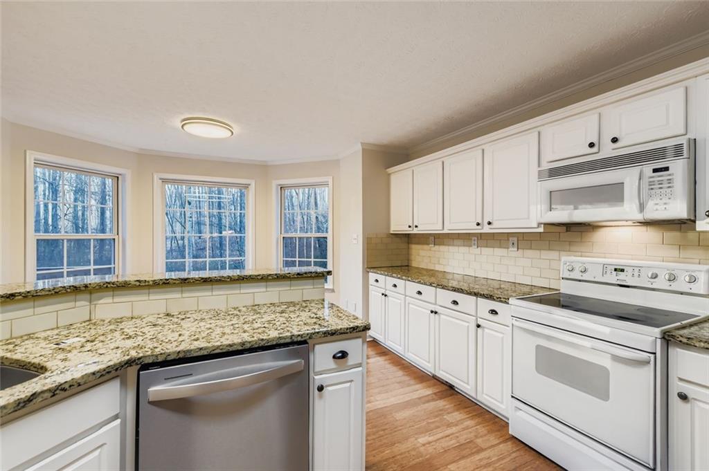 16 Inland Point Newnan, GA 30263 - Photo 7 of 34 a kitchen with granite countertop stainless steel appliances white cabinets and a sink