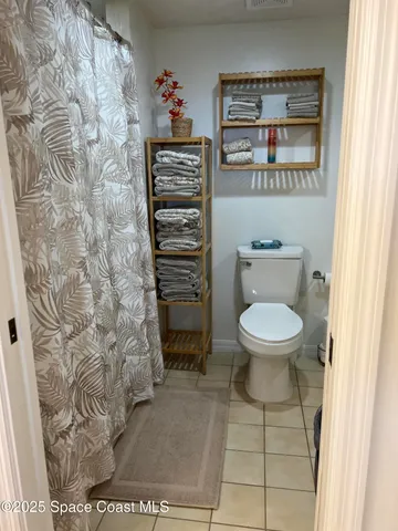 a bathroom with a toilet and a shower curtain