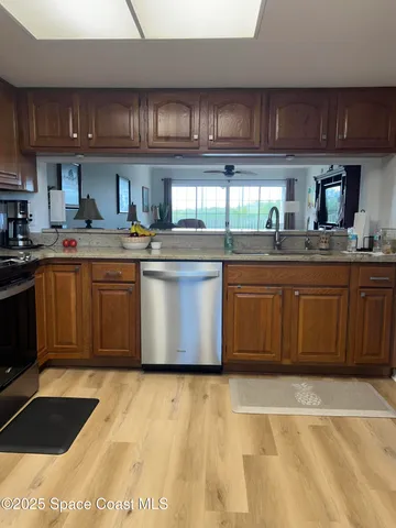 a kitchen with stainless steel appliances granite countertop a sink granite counter tops and a view of living room