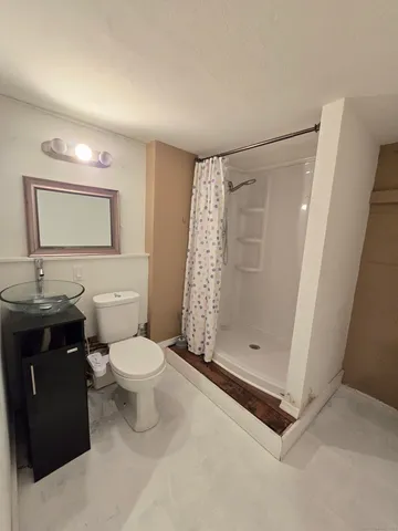 a bathroom with a toilet a sink and shower