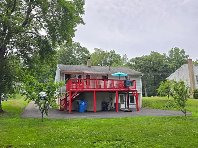 a view of a big building with table and chairs under an umbrella