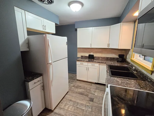 a kitchen with a refrigerator sink and cabinets