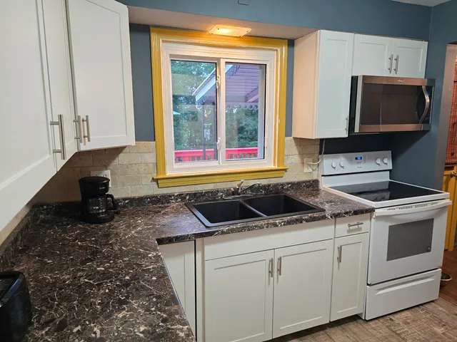 a kitchen with a stove and a white cabinet