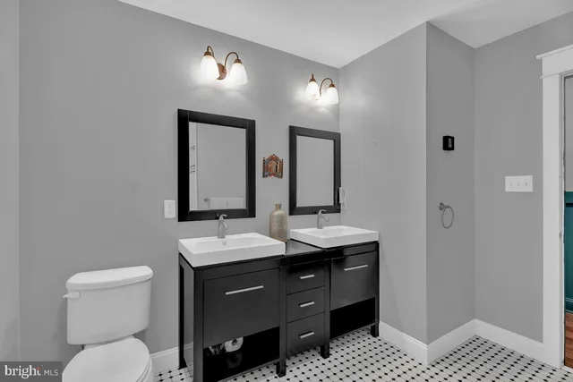 a bathroom with a toilet a sink and mirror