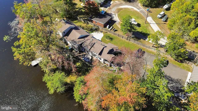 an aerial view of a house with garden space and a lake view