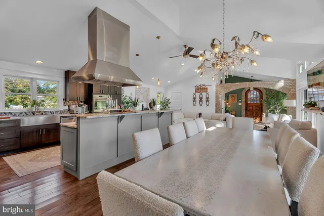 a living room with furniture a chandelier and kitchen view