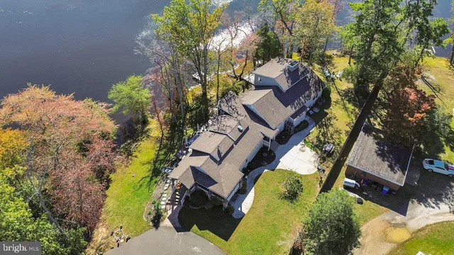 an aerial view of a house with swimming pool and big trees