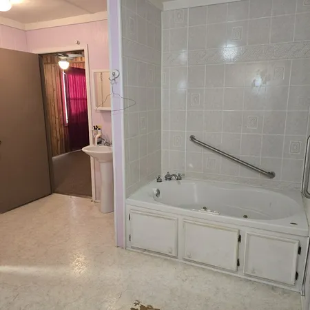 a en suite bathroom with a bathtub sink and mirror