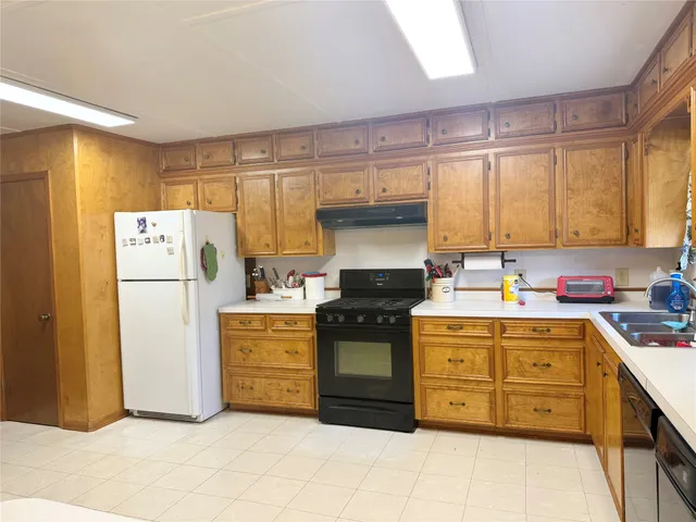a kitchen with a stove a refrigerator and a sink