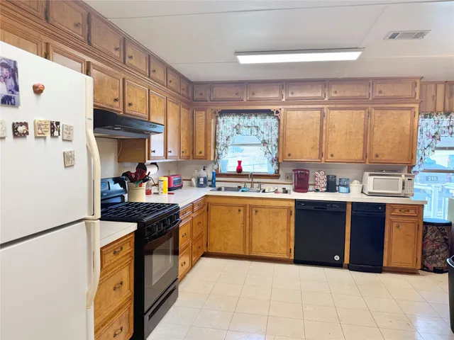 a kitchen with stainless steel appliances granite countertop a sink and a refrigerator