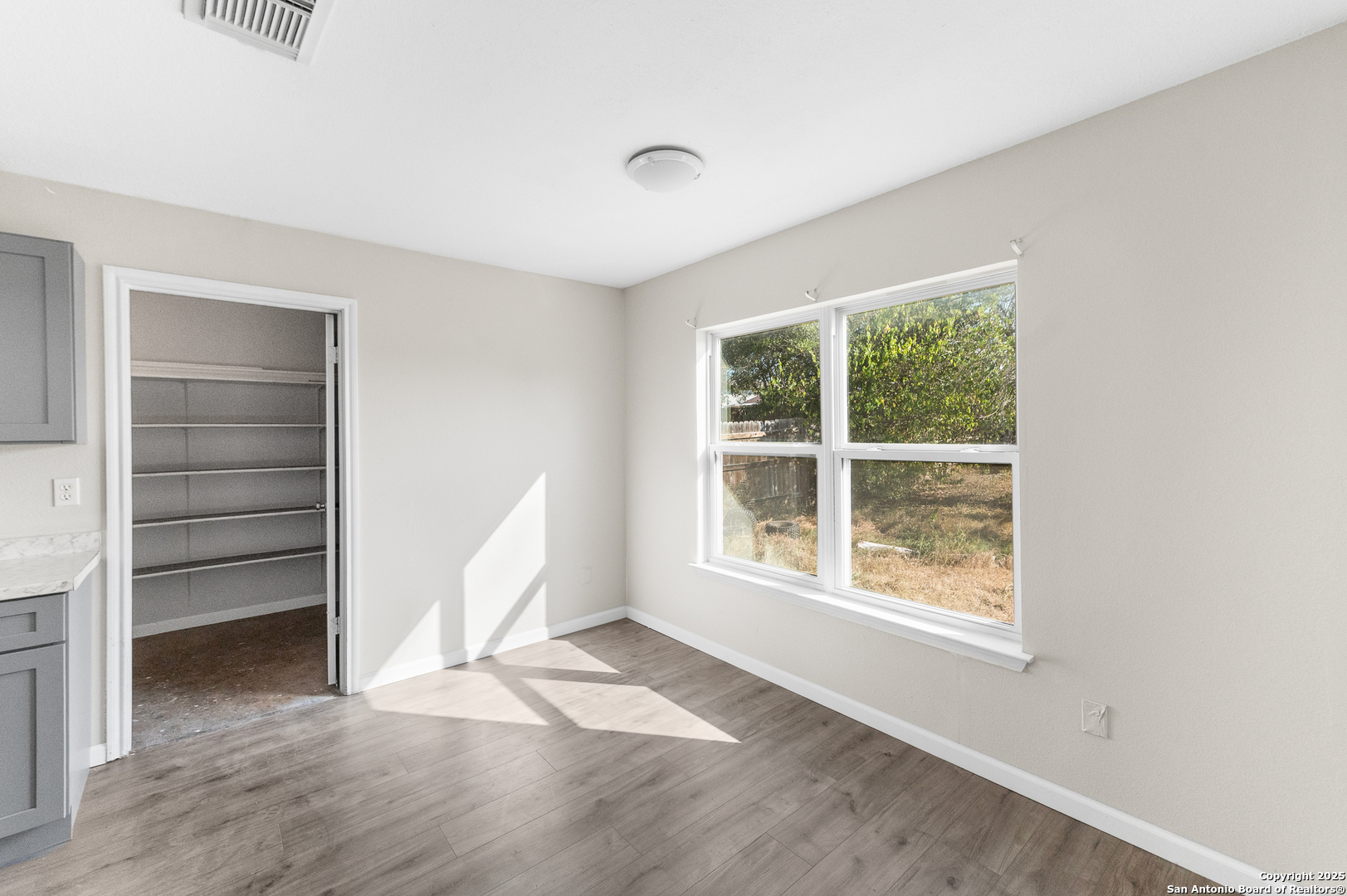 8010 Chestnut Gate Drive Converse, TX 78109 - Photo 12 of 37 a view of an empty room with a window and wooden floor