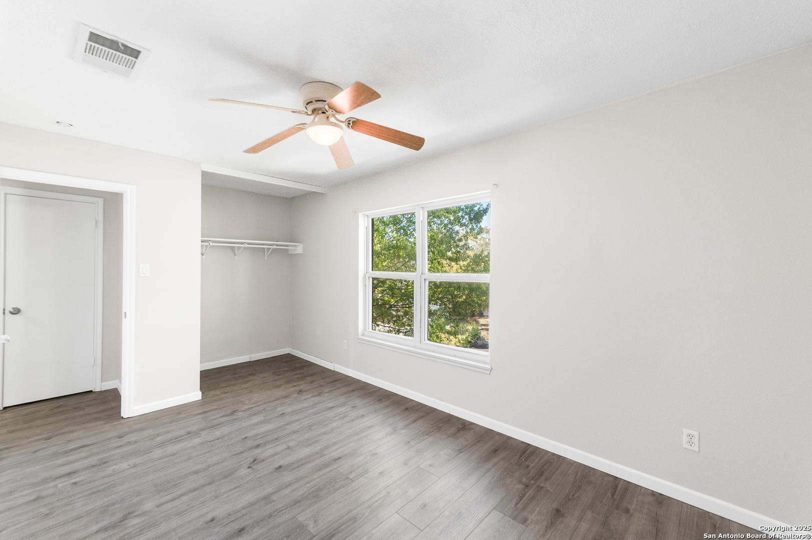 8010 Chestnut Gate Drive Converse, TX 78109 - Photo 13 of 37 an empty room with wooden floor ceiling fan and windows