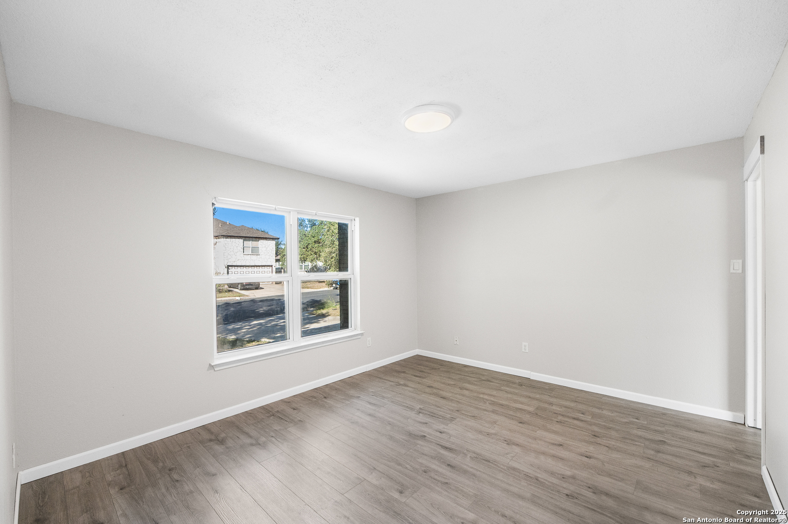 8010 Chestnut Gate Drive Converse, TX 78109 - Photo 16 of 37 an empty room with wooden floor and windows