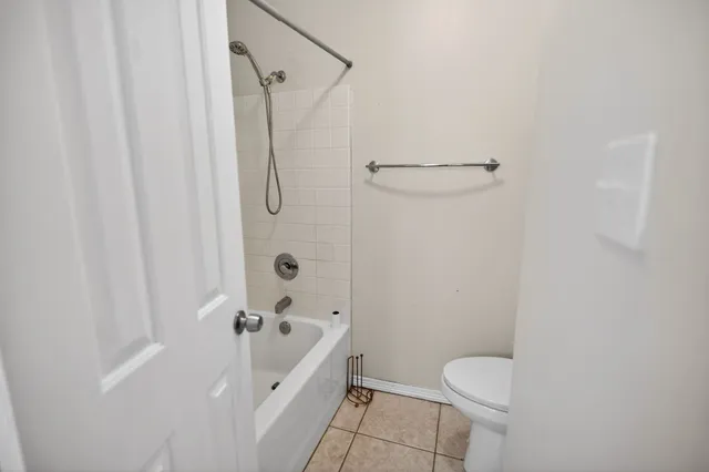 a spacious bathroom with a toilet and shower