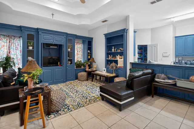 a living room with furniture and a refrigerator