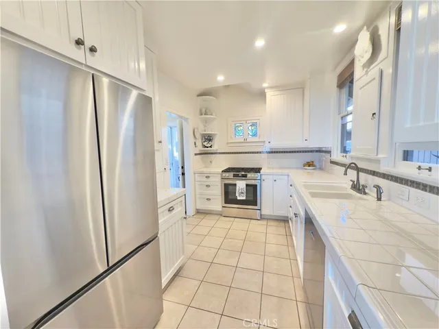 a large kitchen with a stove a refrigerator and a sink