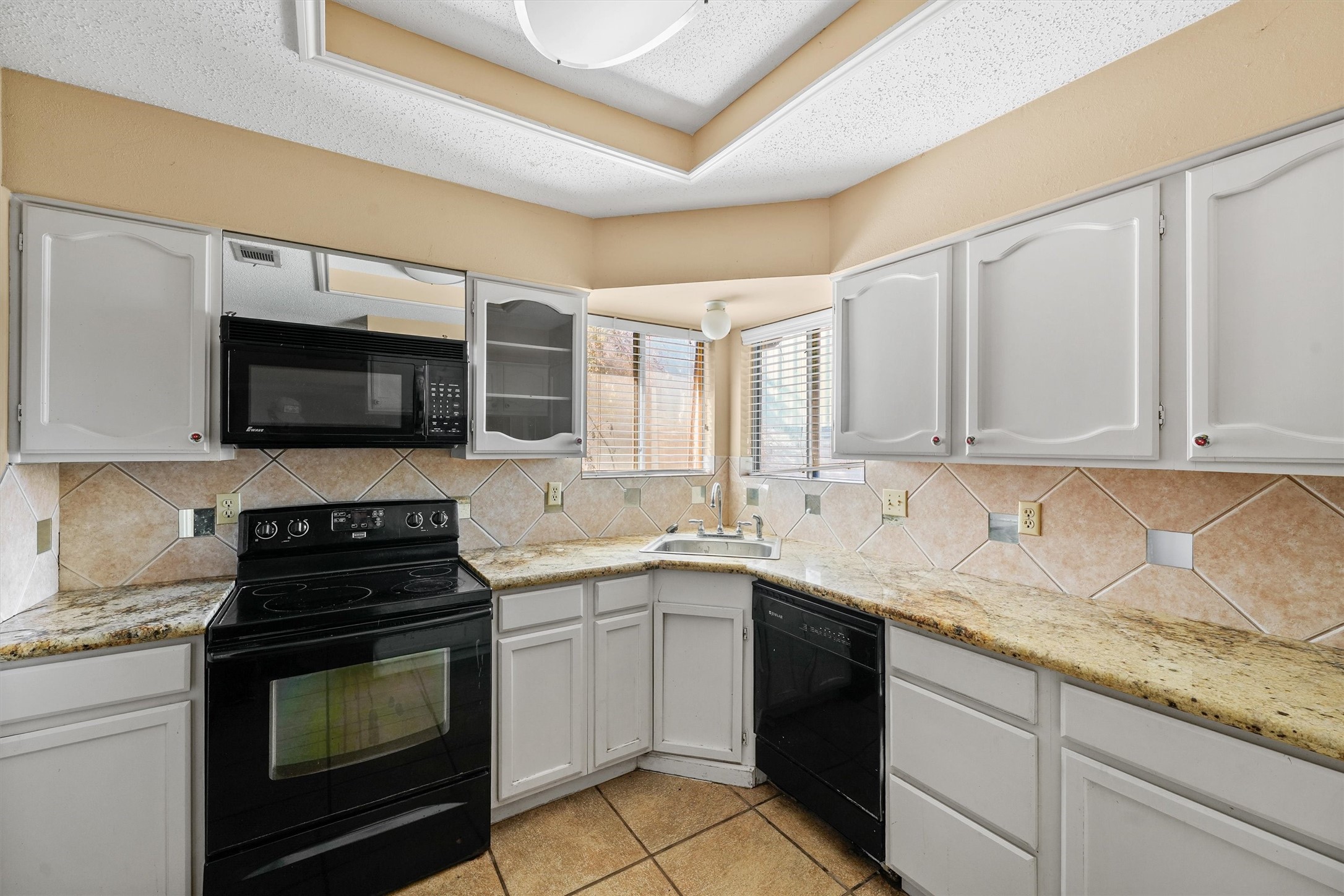 11211 Early Spring Circle Houston, TX 77064 - Photo 13 of 31 a kitchen with a sink stove and microwave
