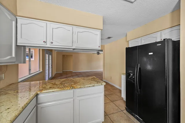 a kitchen with granite countertop cabinets and refrigerator