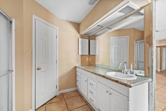 a bathroom with a granite countertop sink and a mirror